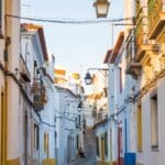 Quiet street with colorful buildings and lamps.