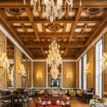 Elegant dining room with chandeliers and decor.