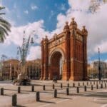 "Arched monument surrounded by palm trees."