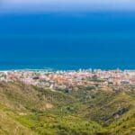 Coastal city overlooking the sea and mountains.