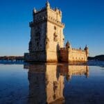 Historic tower reflecting in calm water.