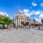 Busy city square with historic buildings.