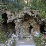 Rocky grotto surrounded by lush greenery.