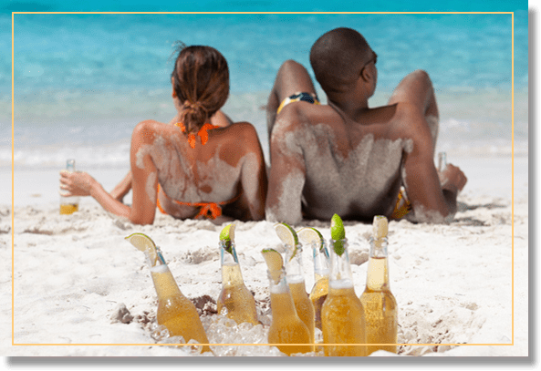 Couple enjoying drinks on a sandy beach.